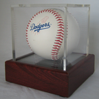 Baseball with Dodgers logo in a clear display case on a wooden base