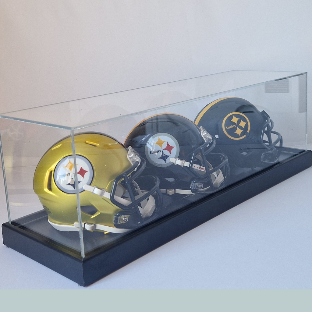 Two football helmets in a clear display case on a white background