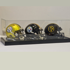 Three Pittsburgh Steelers mini football helmets in a clear display case on a white background