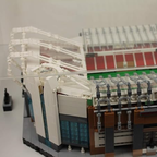 Close-up of a detailed LEGO model of Model of Old Trafford stadium in a clear display case. 
