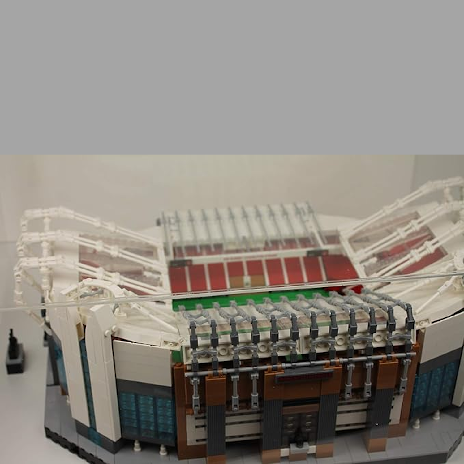 Model of Old Trafford stadium made from Lego building blocks in a clear display case, tight angle view.