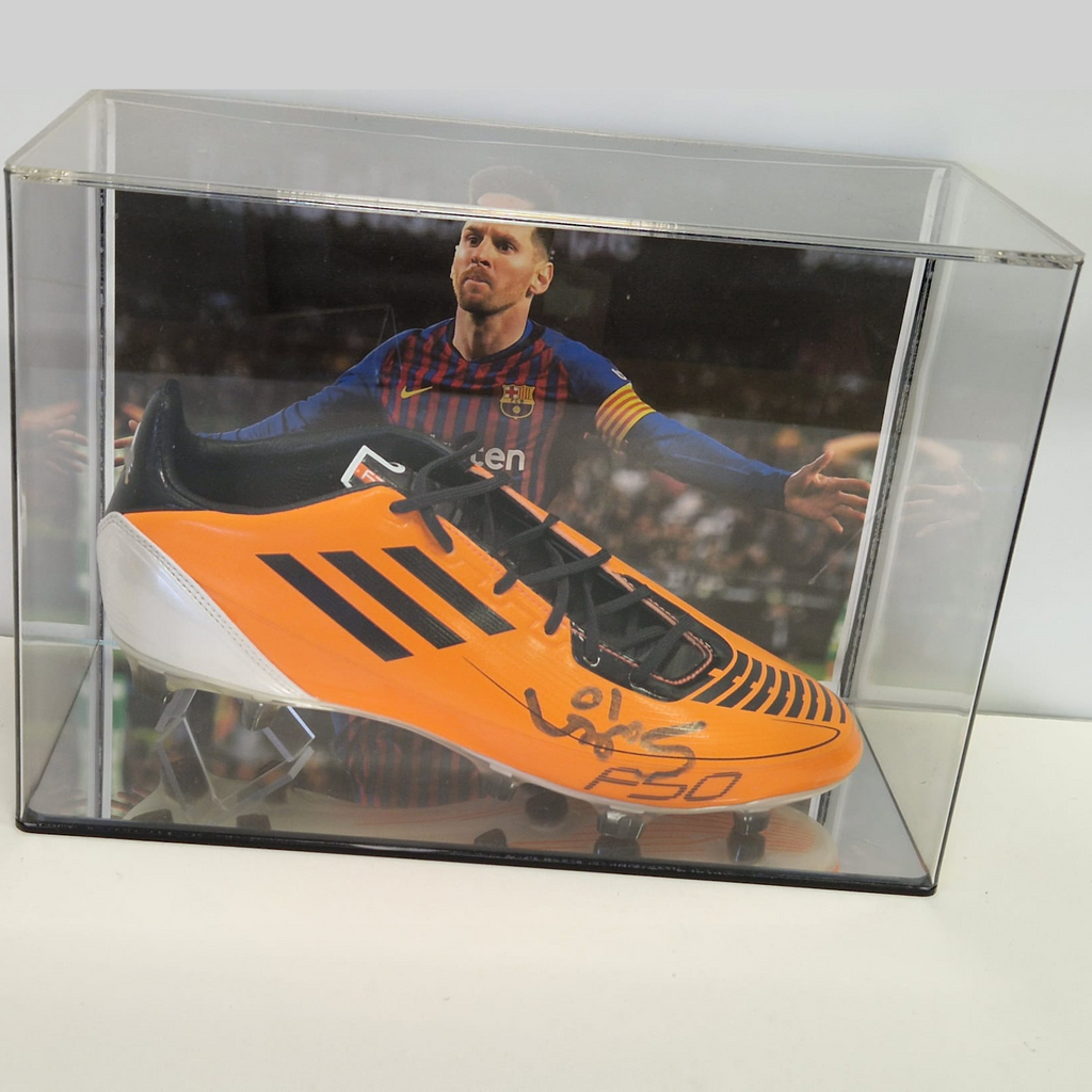 Signed Messi football boot in wall mount display case with background image