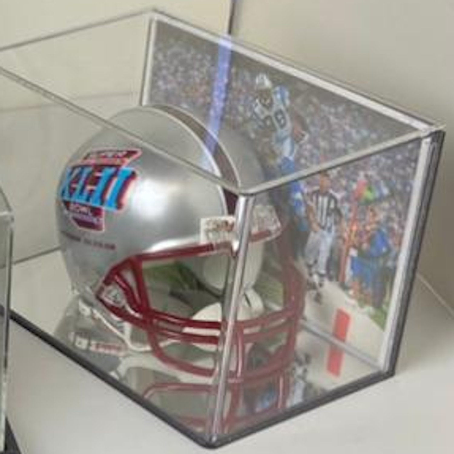 Mini NFL football helmet with red and blue details in a clear display case.